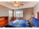 Bedroom features a wood frame bed, ceiling fan, and natural light at 9576 Deerhorn Ct # 50, Parker, CO 80134