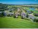 Aerial view of a neighborhood featuring mature trees, manicured lawns and a pond and golf course in the background at 1328 Double Eagle Ct, Castle Rock, CO 80104