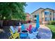 Spacious backyard with a fire pit and an assortment of colorful Adirondack chairs at 1328 Double Eagle Ct, Castle Rock, CO 80104