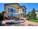 Expansive backyard with a stone patio, dining set, hot tub, and lush green lawn at 1328 Double Eagle Ct, Castle Rock, CO 80104