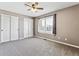 Bright bedroom features neutral carpet and walls, ceiling fan, and shutters for plenty of natural light at 1328 Double Eagle Ct, Castle Rock, CO 80104