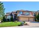 Stunning two-story home featuring a three-car garage and a beautifully landscaped front yard under a clear blue sky at 1328 Double Eagle Ct, Castle Rock, CO 80104