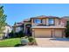 Charming two-story home featuring stone accents, a well-manicured lawn, and an attached three car garage at 1328 Double Eagle Ct, Castle Rock, CO 80104