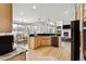 Open-concept kitchen featuring light wood cabinets, granite countertops, stainless steel appliances, and hardwood floors at 1328 Double Eagle Ct, Castle Rock, CO 80104