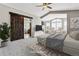 Bright main bedroom features a ceiling fan, sitting area and ensuite bathroom with a barn door for added privacy at 1328 Double Eagle Ct, Castle Rock, CO 80104