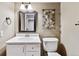 Neutral powder room with white vanity, decorative mirror, accent lighting and a decorative branch accent on the wall at 1328 Double Eagle Ct, Castle Rock, CO 80104