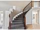 Elegant curved staircase with wood railing and wrought iron spindles at 1328 Double Eagle Ct, Castle Rock, CO 80104