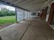 Spacious covered back patio with a concrete floor and enclosed with white tarps and windows at 387 Tucson St, Aurora, CO 80011