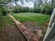 Large backyard with a brick and concrete pathway and grass at 387 Tucson St, Aurora, CO 80011