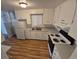Bright kitchen with white cabinets, laminate flooring, and stainless-steel sink at 387 Tucson St, Aurora, CO 80011