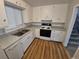 Updated kitchen featuring white cabinets, laminate floors, and stainless-steel appliances at 387 Tucson St, Aurora, CO 80011