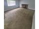 Spacious living room featuring neutral carpeting, a brick fireplace, and a large window at 387 Tucson St, Aurora, CO 80011