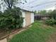 A white storage shed in the backyard with overgrown grass at 387 Tucson St, Aurora, CO 80011