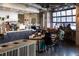 Warm coffee shop with exposed ductwork, modern counters, and garage door window at 2140 S Ash St # 101, Denver, CO 80222