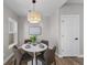 Bright dining room featuring a modern pendant light and a round white dining table with seating for four at 2140 S Ash St # 101, Denver, CO 80222