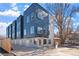 Eye-level exterior view of modern townhome complex with blue and gray accents and individual garages at 2140 S Ash St # 101, Denver, CO 80222