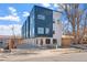 Exterior view of modern townhome complex with blue and gray accents and individual garages at 2140 S Ash St # 101, Denver, CO 80222