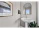 Chic powder room with a pedestal sink, modern mirror, and stylish decor, perfect for guests at 2140 S Ash St # 101, Denver, CO 80222