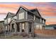 Beautiful gray two-story home featuring stone accents, gabled roof, and professionally landscaped front yard at 21411 E 60Th Ave, Aurora, CO 80019