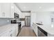 Well-lit kitchen featuring stainless steel appliances, white cabinets, and quartz countertops at 21411 E 60Th Ave, Aurora, CO 80019