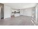 Open-concept living and kitchen area with modern gray floors, white cabinets, and natural light at 21411 E 60Th Ave, Aurora, CO 80019