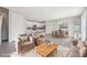 Open-concept living room with modern furnishings, a cozy rug, and easy access to the dining area and kitchen at 21411 E 60Th Ave, Aurora, CO 80019