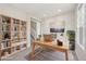 Bright home office with a wooden desk, built-in shelves, and a large window for natural light at 21411 E 60Th Ave, Aurora, CO 80019