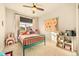 Charming bedroom featuring a green bed frame, natural light, and a ceiling fan at 8378 Arapahoe Peak St, Littleton, CO 80125