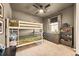 Bunk bedroom with neutral tones, a window with curtains, and a gray bookcase at 8378 Arapahoe Peak St, Littleton, CO 80125