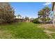 Green back yard with lush lawn, mature trees, and a wooden privacy fence at 4650 S Idalia St, Aurora, CO 80015
