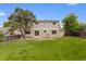 The large back yard features an expansive lawn, mature trees, privacy fence, and back of the house at 4650 S Idalia St, Aurora, CO 80015