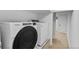 Modern laundry room features new Whirlpool washer and dryer, ample space and bright white walls at 4650 S Idalia St, Aurora, CO 80015