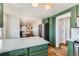 Stylish kitchen featuring green cabinetry, stainless steel appliances, and an adjacent dining area at 4648 Josephine St, Denver, CO 80216
