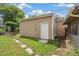 Exterior view of the backyard, featuring a door leading to the yard, grass, and concrete walkway at 1330 Oak Pl, Thornton, CO 80229
