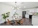 A dining area with a glass table, modern light fixture, and a view into the kitchen, enhancing the home's appeal at 1330 Oak Pl, Thornton, CO 80229