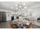 Open concept featuring a dining area with modern lighting, kitchen with white cabinets and stainless appliances at 1330 Oak Pl, Thornton, CO 80229