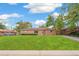 Brick home boasting a well-manicured front lawn and mature trees, complemented by a clear blue sky and street view at 1330 Oak Pl, Thornton, CO 80229