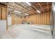 Spacious garage featuring plywood walls, an exposed ceiling, and concrete flooring, offering ample storage and workshop space at 1330 Oak Pl, Thornton, CO 80229
