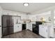 Modern kitchen featuring white cabinets, black appliances, and stylish countertops, creating a sleek culinary space at 1330 Oak Pl, Thornton, CO 80229