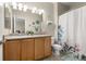 Bright bathroom featuring double vanity, modern lighting, and shower with patterned shower curtain at 848 Sagebrush Dr, Brighton, CO 80603