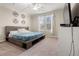 Inviting bedroom featuring a platform bed frame, natural light, and neutral carpeting at 848 Sagebrush Dr, Brighton, CO 80603