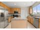 Well-lit kitchen featuring stainless steel appliances, granite countertops, and spacious center island at 848 Sagebrush Dr, Brighton, CO 80603