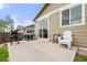 Outdoor concrete patio featuring a sliding glass door, grills, and outdoor seating at 848 Sagebrush Dr, Brighton, CO 80603