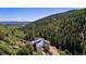 The house is set among a landscape of lush green forest on the side of a mountain at 2602 Hidden Valley Road, Sedalia, CO 80135