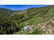 Stunning view of the house nestled in the mountains and surrounded by lush greenery at 2602 Hidden Valley Road, Sedalia, CO 80135