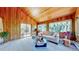Wood paneled living room with vaulted ceilings and access to a sunny balcony at 2602 Hidden Valley Road, Sedalia, CO 80135