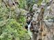 Picturesque waterfall cascading down rocky cliffs surrounded by lush greenery at 2602 Hidden Valley Road, Sedalia, CO 80135
