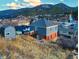 Two-story home with brick foundation and siding is nestled among the mountainside community at 1520 Virginia St, Idaho Springs, CO 80452