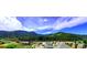 Picturesque mountain town view with lush greenery and a bright blue, cloudy sky at 1520 Virginia St, Idaho Springs, CO 80452