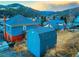 View of a town nestled among snowy mountains with a blue shed in the foreground at 1520 Virginia St, Idaho Springs, CO 80452